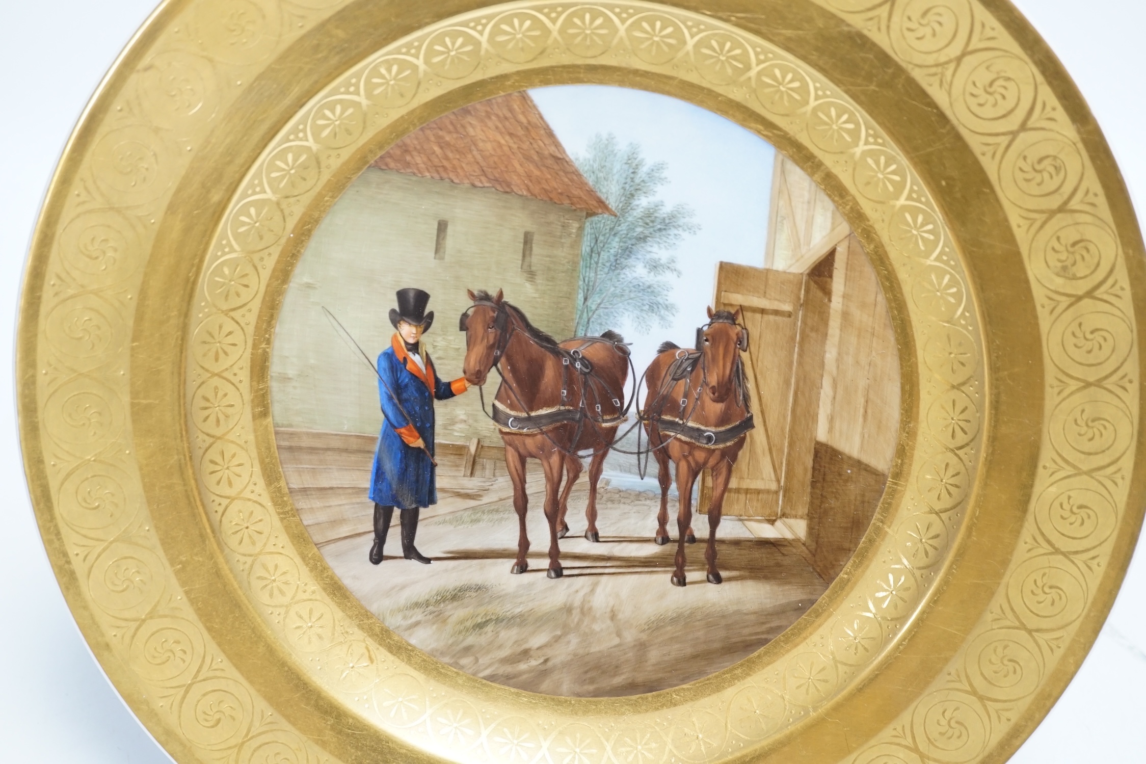A Berlin porcelain dish painted with a groom with horses, first half of 19th century, 25cm diameter
